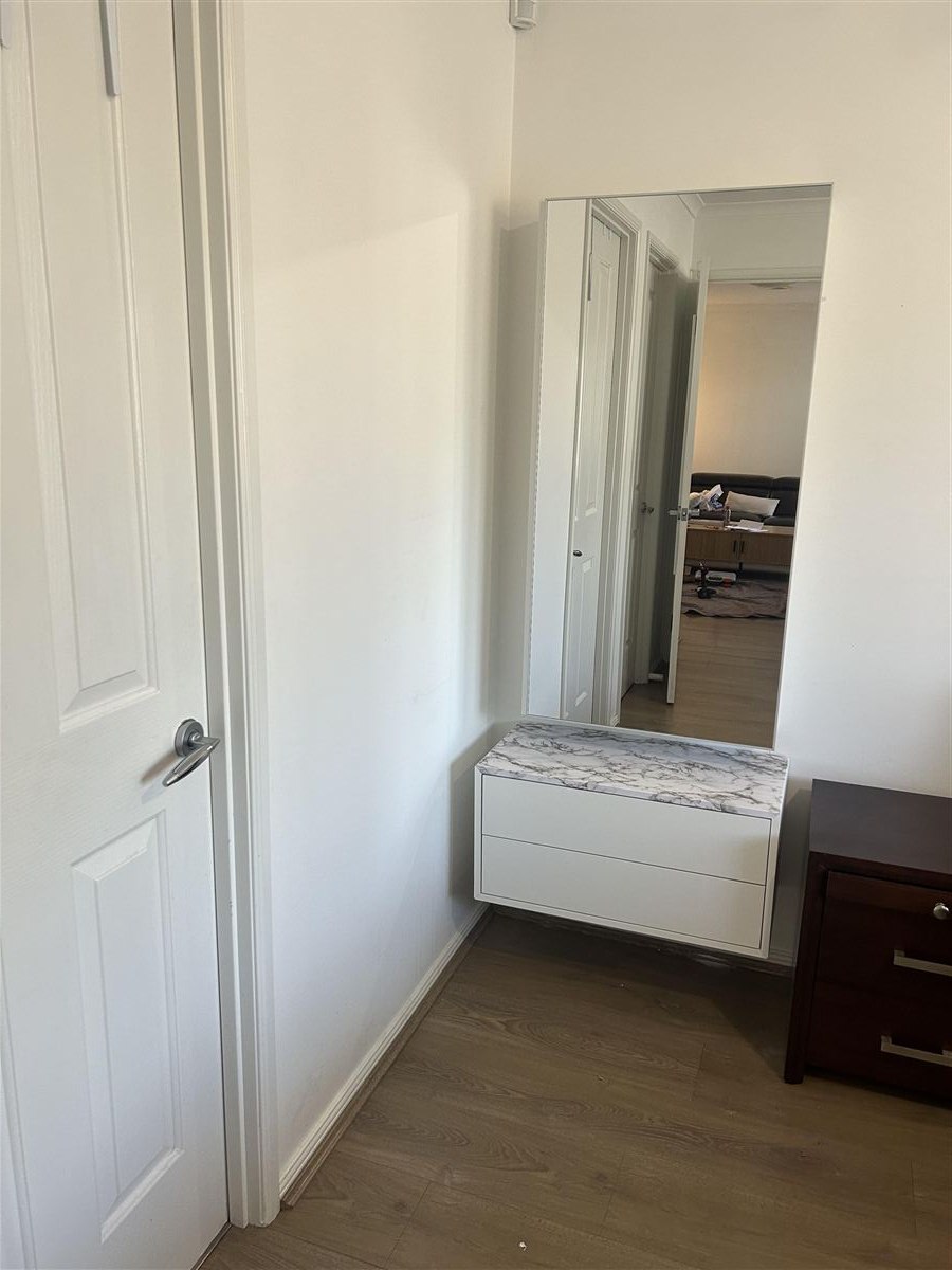 Floating cabinet with marble-looking top and full-length mirror after installation