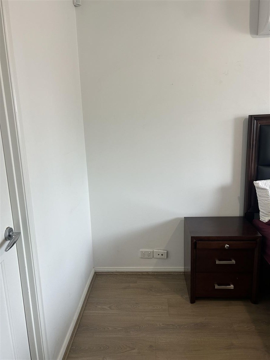 Bare bedroom wall before custom cabinet installation