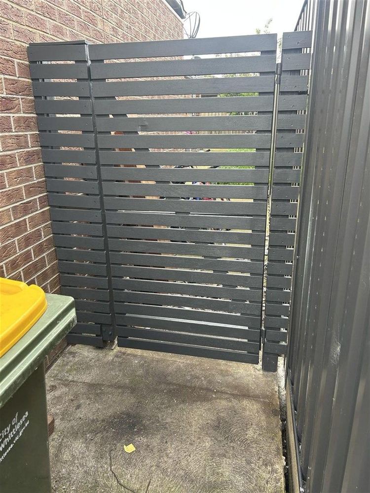 Freshly repainted charcoal horizontal slat gate after repair